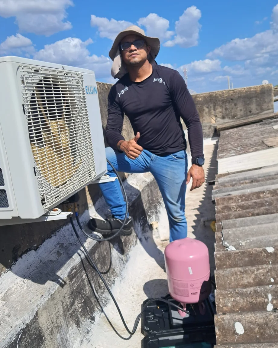 Técnico da MAX Climatização em serviço numa laje, ao lado da condensadora instalada